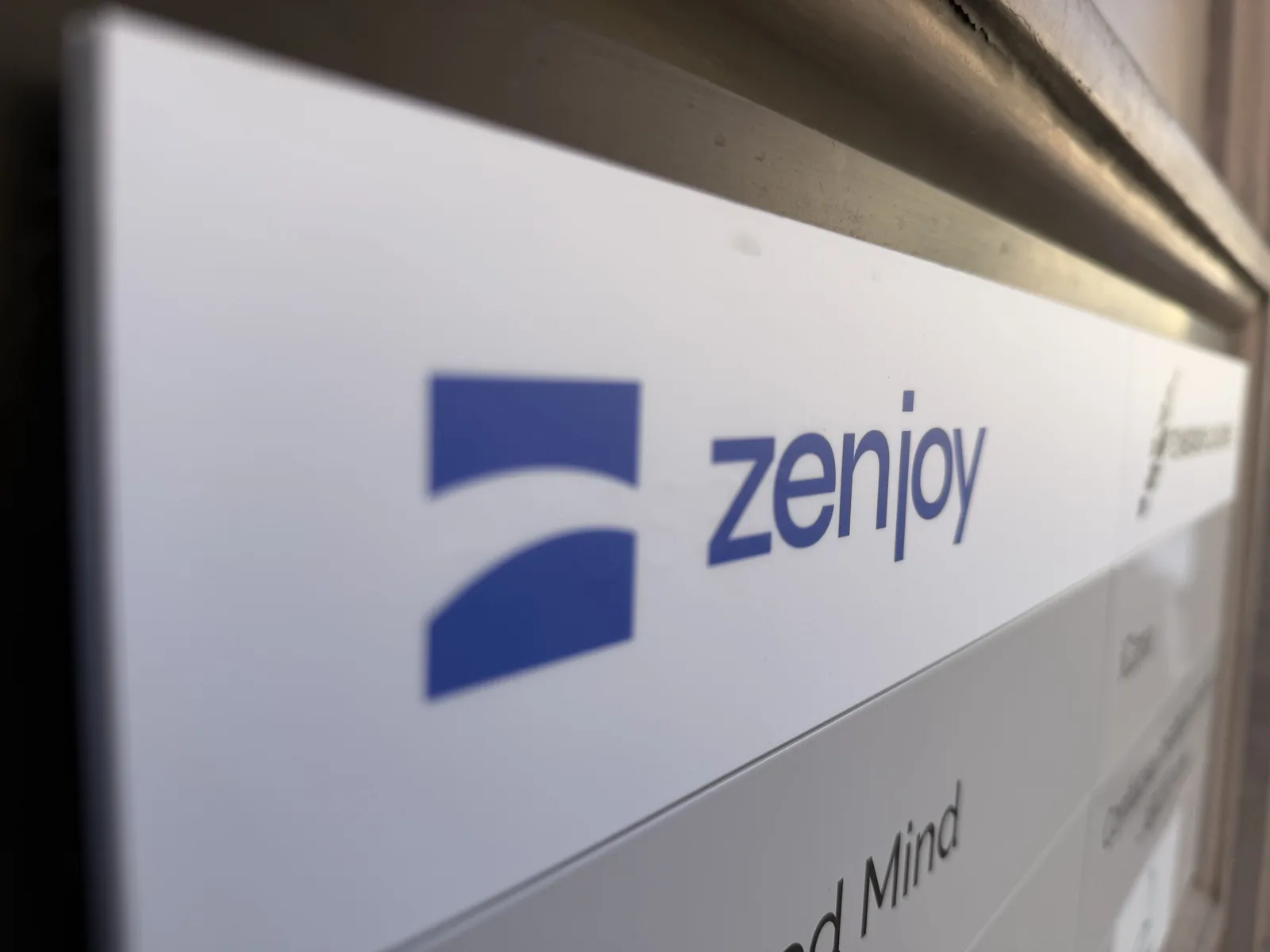 Naambord van Zenjoy aan de ingang van het kantoor